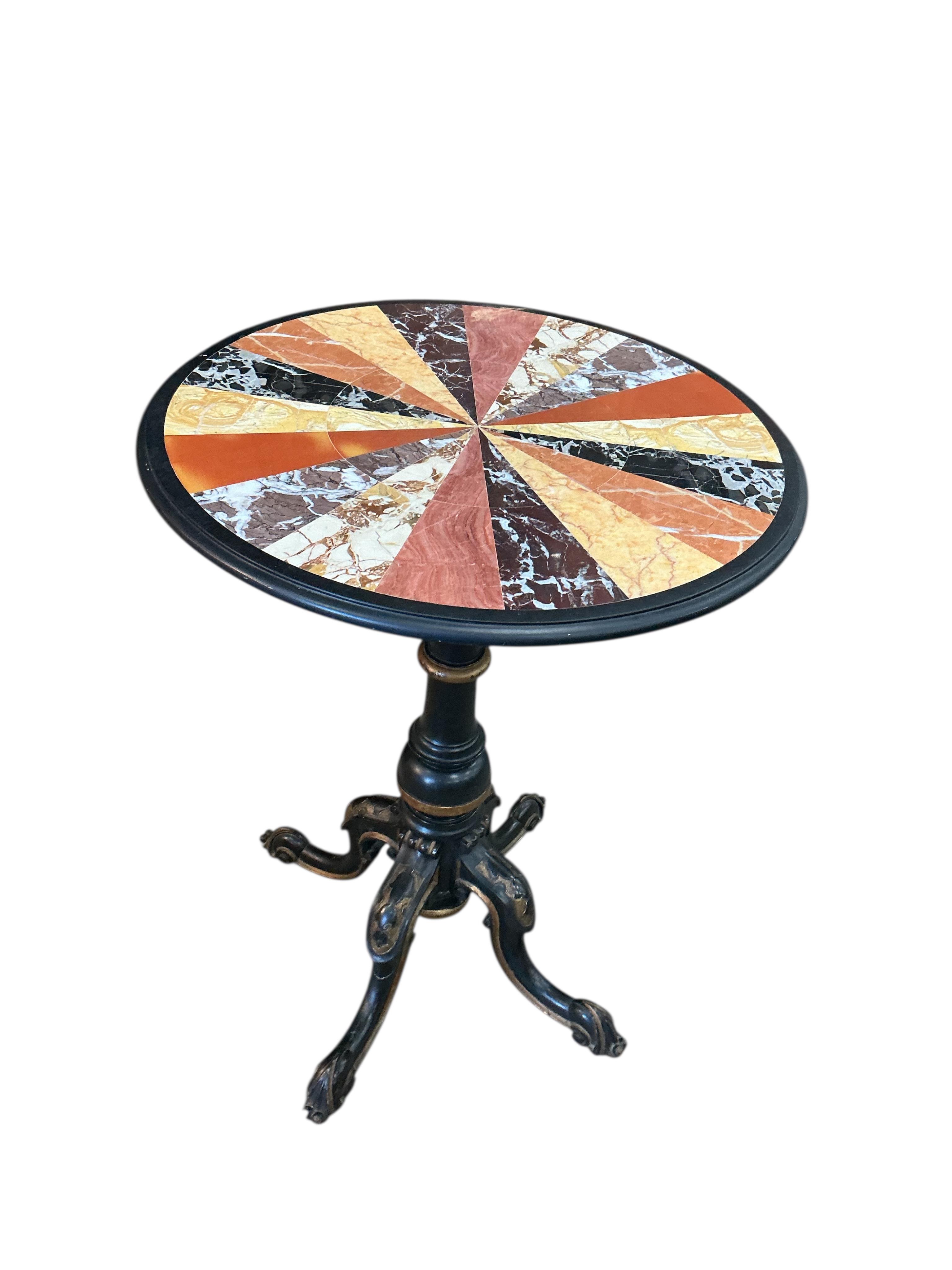 A circular specimen marble occasional table on a Victorian ebonised tripod base, diameter 53cm, height 69cm